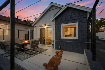 a dog sitting on a patio in front of a house at The Shining Sea A in Oceanside