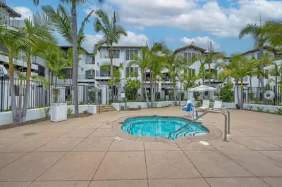 a pool with a water slide in a courtyard with palm trees at Heated Pool & Hot Tub Access, Walk 2 Omni Resort, Free Parking, Wi-Fi, Washer & Dryer in Encinitas