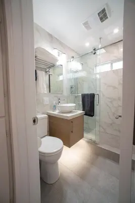 a bathroom with a toilet and a sink and a shower at La Jolla Windansea Luxury Apt in San Diego
