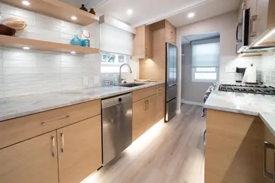 a kitchen with wooden cabinets and stainless steel appliances at La Jolla Windansea Luxury Apt in San Diego