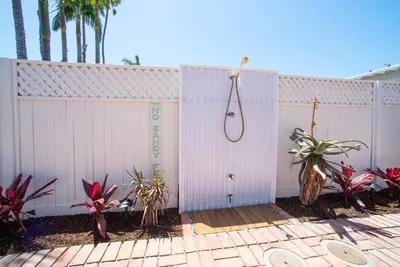 a white fence with a shower and some plants at La Jolla Windansea Luxury Cottage in San Diego
