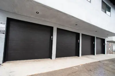 a row of four garage doors on a building at 5BD Family, Event Friendly 4plex Steps2Beach in San Diego