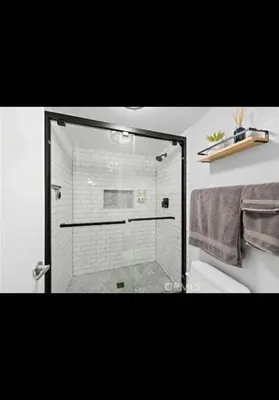 a shower with a glass door in a bathroom at Golden Gateaway in Dana Point