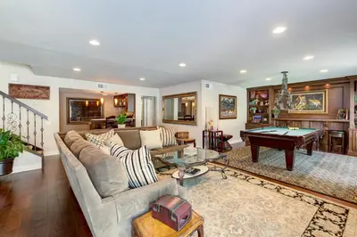 a living room with a couch and a pool table at The Sanctuary in Laguna Hills