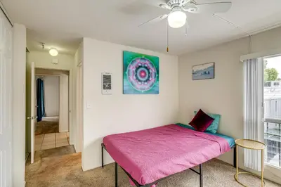 a bedroom with a pink bed and a window at Condo Near Hospitals and half Mi to Mission Bay! in San Diego