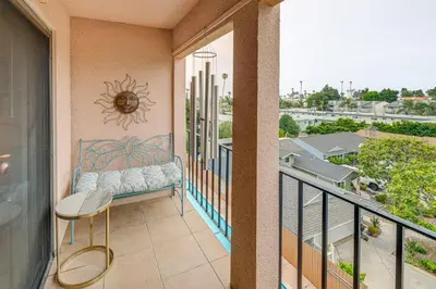 a balcony with a bench and a sun on the wall at Condo Near Hospitals and half Mi to Mission Bay! in San Diego