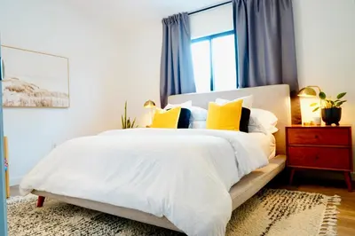 a bedroom with a large white bed with yellow pillows at Private Family Friendly Guest Home in San Diego