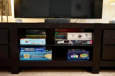 a book shelf filled with games and a flat screen tv at Private Family Friendly Guest Home in San Diego