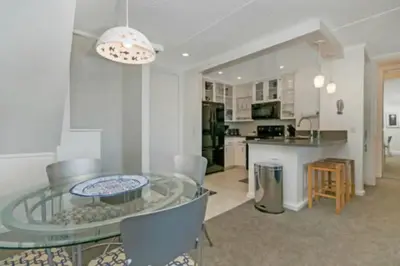 a dining room and kitchen with a glass table and chairs at C302 - Surfside Sactuary in Oceanside