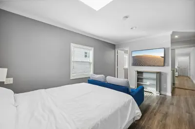 a bedroom with a white bed and a blue couch at 1628 West Oceanfront Oasis - All Units in Newport Beach