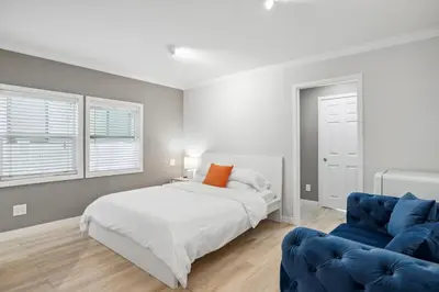 a bedroom with a bed and a blue couch at 1628 West Oceanfront Oasis 2 in Newport Beach