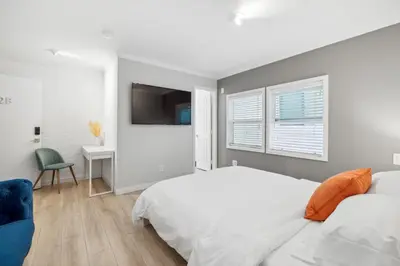 a white bedroom with a bed and a desk at 1628 West Oceanfront Oasis 2 in Newport Beach