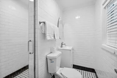 a white bathroom with a toilet and a shower at 1628 West Oceanfront Oasis 1,2,3 in Newport Beach