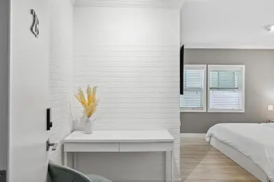 a white bedroom with a bed and a table at 1628 West Oceanfront Oasis 1,2,3 in Newport Beach