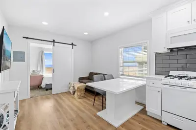 a white kitchen with a table and a couch at 1628 West Oceanfront Oasis 4,5,6,7,8,9 in Newport Beach