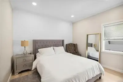 a white bedroom with a bed and a mirror at 1628 West Oceanfront Oasis 4,5,6,7,8,9 in Newport Beach
