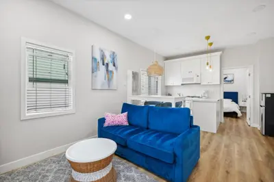 a living room with a blue couch and a kitchen at 1628 West Oceanfront Oasis 4,5,6,7,8,9 in Newport Beach