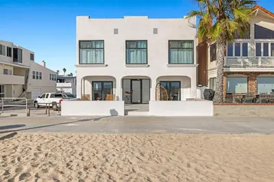 a white house with a palm tree on the beach at 1628 West Oceanfront Oasis 5 in Newport Beach