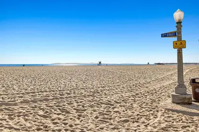 a street sign on a sandy beach with a light pole at 1628 West Oceanfront Oasis 5 in Newport Beach