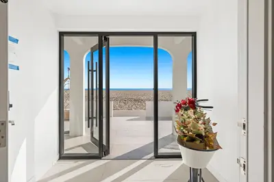 a room with a view of the beach through a glass door at 1628 West Oceanfront Oasis 5 in Newport Beach
