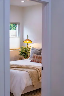 a bedroom with a bed and a window and a lamp at Newly Remodeled Uptown Chic in San Diego