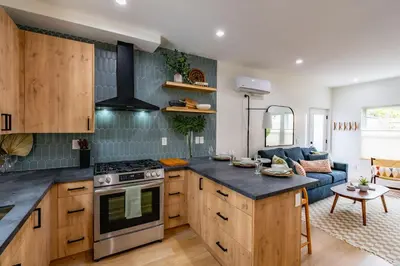 a kitchen with a stove top oven next to a living room at Newly Remodeled Uptown Chic in San Diego