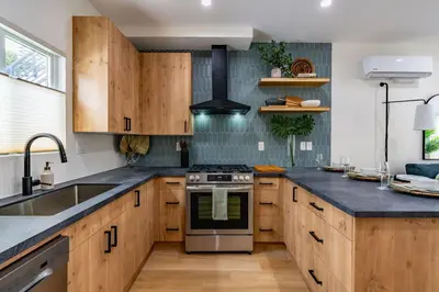 a kitchen with wooden cabinets and a stove top oven at Newly Remodeled Uptown Chic in San Diego