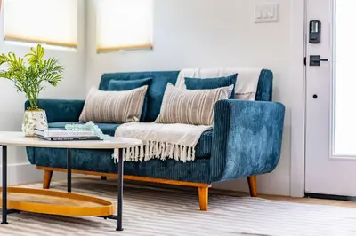 a blue couch in a living room with a table at Quaint Studio in Charming Marston Hills in San Diego