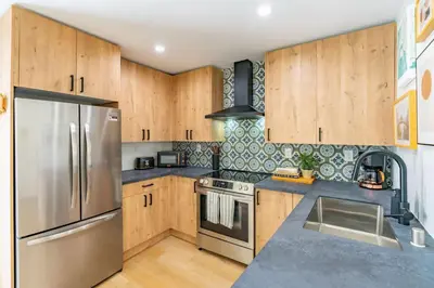 a kitchen with wooden cabinets and a stainless steel refrigerator at Quaint Studio in Charming Marston Hills in San Diego
