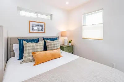 a bedroom with a bed with blue pillows and a window at Quaint Studio in Charming Marston Hills in San Diego