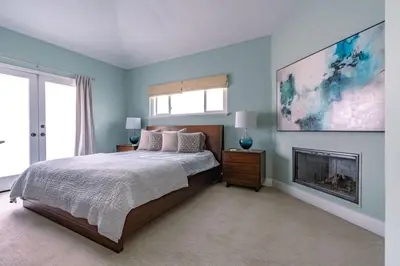 a bedroom with a large bed and a fireplace at Upscale Beach Cottage a Block to the Beach Sauna in Encinitas