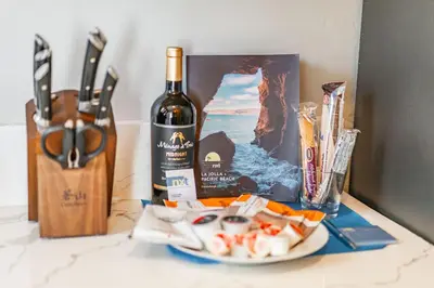 a bottle of wine and a plate of food on a counter at PB Compound Getaway Steps to Surf and Sand in San Diego