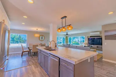 a kitchen and living room with a sink and a table at PB Compound Getaway Steps to Surf and Sand in San Diego