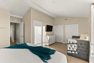 a bedroom with a bed and a couch and a television at Mission Beach Marvel in San Diego