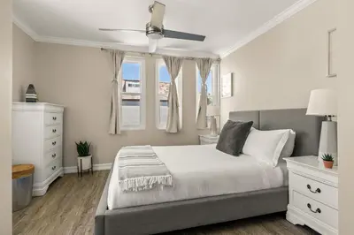 a bedroom with a bed and two windows at Mission Beach Marvel in San Diego