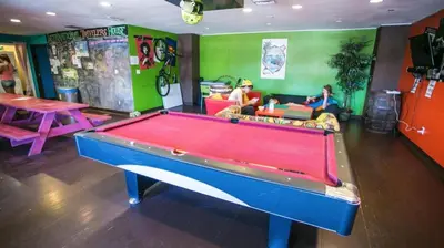 a pool table in a living room with two people at ITH Colive Balboa Park in San Diego