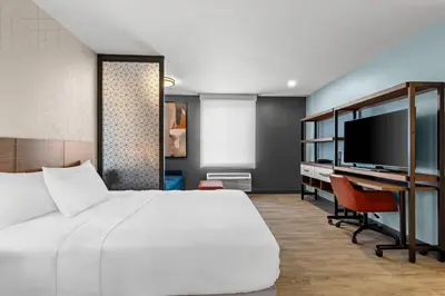 a bedroom with a bed and a desk and a tv at Everhome Suites Temecula in Temecula