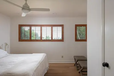 a white bedroom with a bed and two windows at La Jolla Shores Family Getaway in San Diego