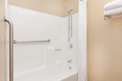 a bathroom with a shower and a tub at Ramada by Wyndham San Diego Poway Miramar in Poway