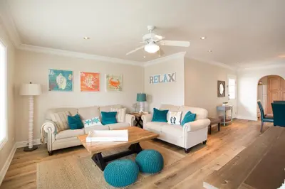 a living room with two couches and a table at Lower West Newport in Newport Beach