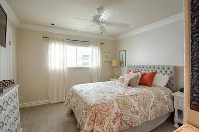 a bedroom with a bed and a ceiling fan at Lower West Newport in Newport Beach