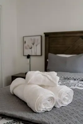 a pile of towels sitting on top of a bed at Chic 2Bed And Large Serene Backyard in Heart of SD in San Diego