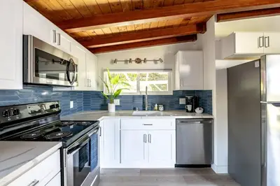 a kitchen with white cabinets and a sink at Chic Studio Suite Serene Backyard in Heart of SD in San Diego