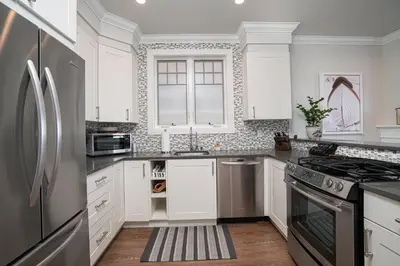 a kitchen with white cabinets and a stainless steel refrigerator at 1225 W Balboa Blvd A in Newport Beach