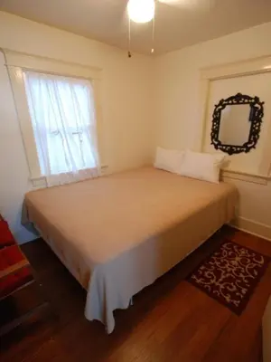 a bedroom with a bed with a mirror and a window at Lower West Newport in Newport Beach