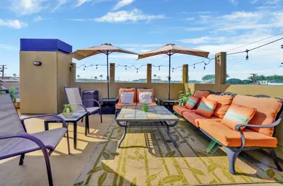 a patio with furniture and umbrellas on a roof at 4 Bedrooms in Newport Beach