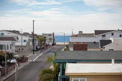an empty street in a town with houses and the ocean at 4 Bedrooms in Newport Beach
