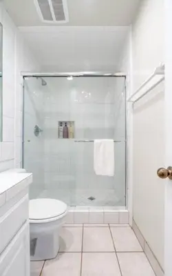 a white bathroom with a shower and a toilet at Christina - Beachfront in Newport Beach