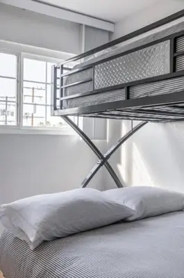 a metal bunk bed in a white room with a pillow at Alexander - Oceanview in Newport Beach