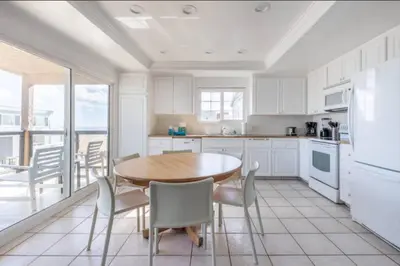 a kitchen with white cabinets and a table and chairs at Alexander - Oceanview in Newport Beach